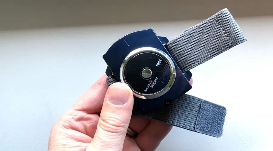 Sleep Connection device held in hand showing test button